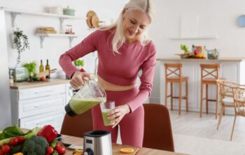 Frau macht gesunden Smoothie in Küche