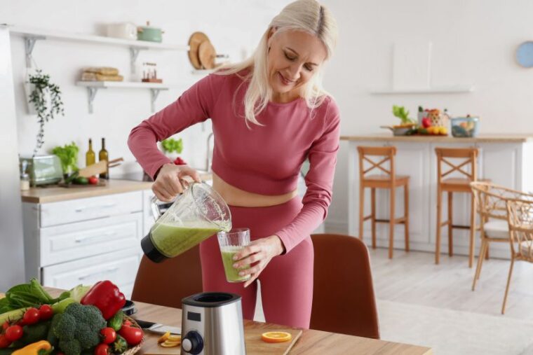 Frau macht gesunden Smoothie in Küche