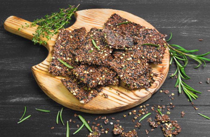 Low Carb-Cracker mit Chia auf einem Holzbrett serviert