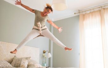 Frau springt problemlos auf Matratze dank Beckenbodentraining