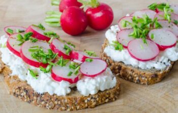 Scheiben Vollkornbrot mit Hüttenkäse bestrichen und Radieschengarnitur