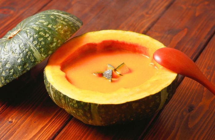 Kürbissuppe angerichtet im ausgehöhlten Kürbis