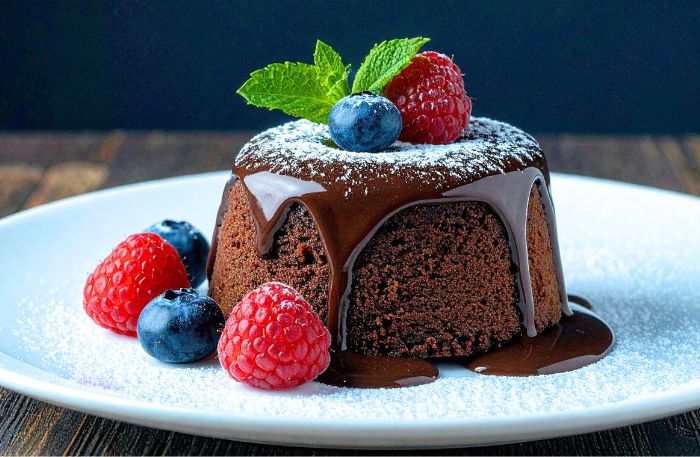 Schokokuchen auf einem Teller angerichtet mit Beeren